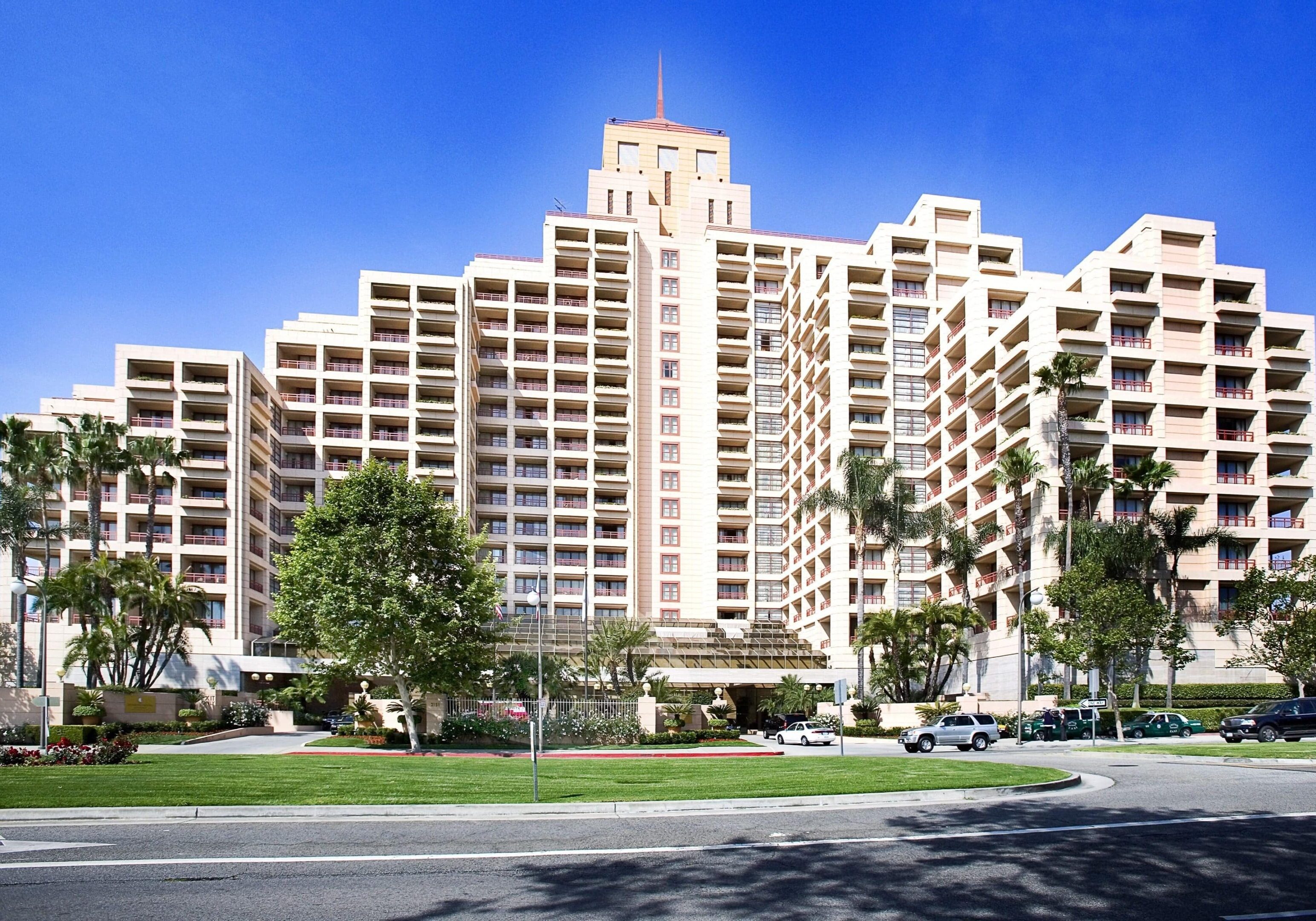 Modern multi-story apartment complex under a clear blue sky.